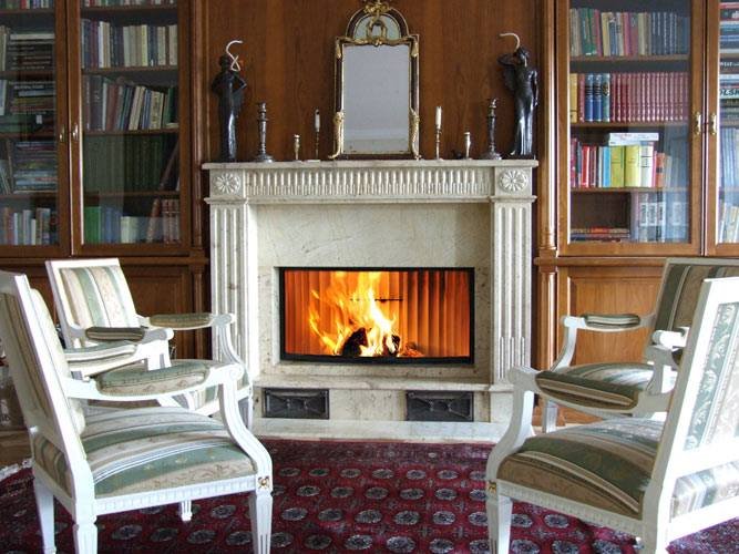 Stylowy kamienny portal kominkowy ze zdobionym gzymsem w domowej bibliotece